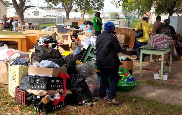 Evicted Lefleur School residents' belongings out in the open while Joe Sellidon (yellow shirt) & Peter Marais (leather jacket) assess the situation. Photo by Renee Sellidon